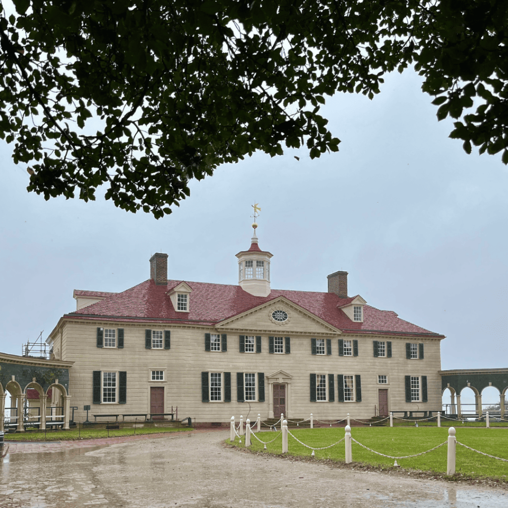 Historic Mount Vernon mansion with red roof and cupola on a rainy day.