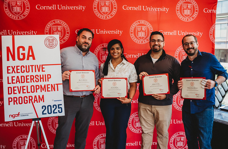 Four ELDP participants hlding certificates and smiling